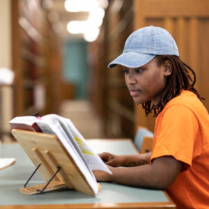 Woman in hat studying in a library