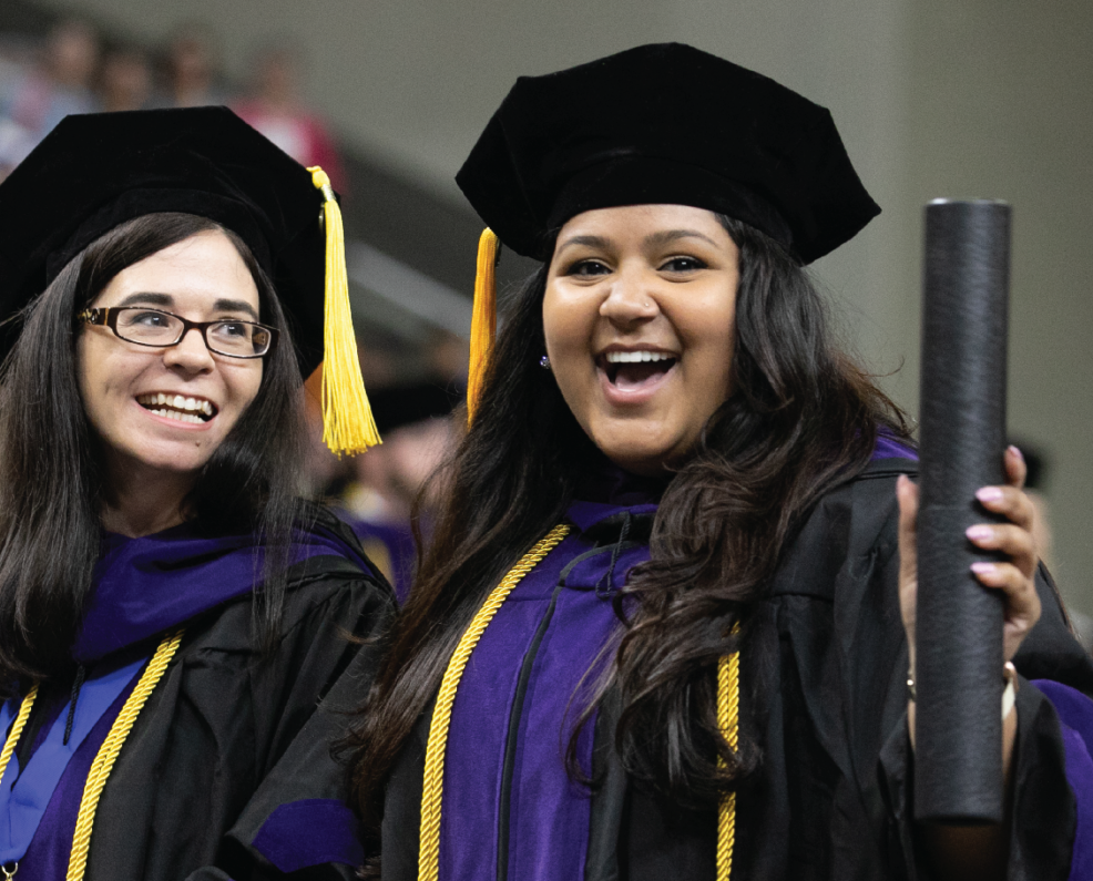 Two female graduates, holding a diploma