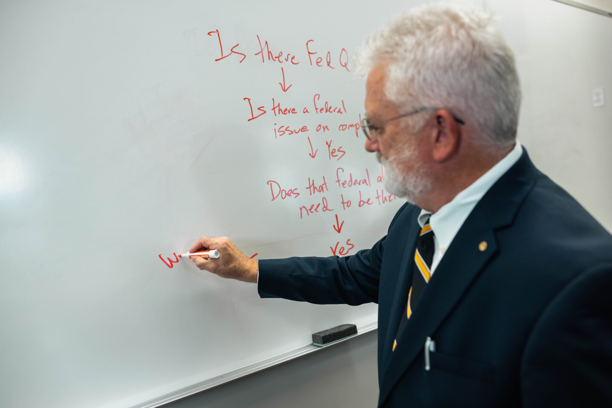 Professor writing on a dry erase board