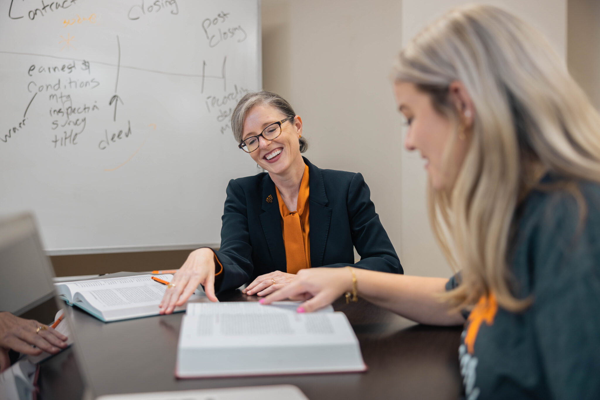 Dean Sneddon reading a textbook with a student