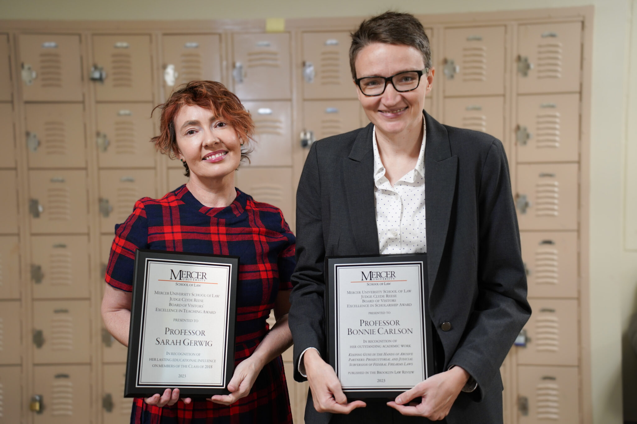 Professor Sarah Gerwig and Professor Bonnie Carlson holding Faculty Award plaques