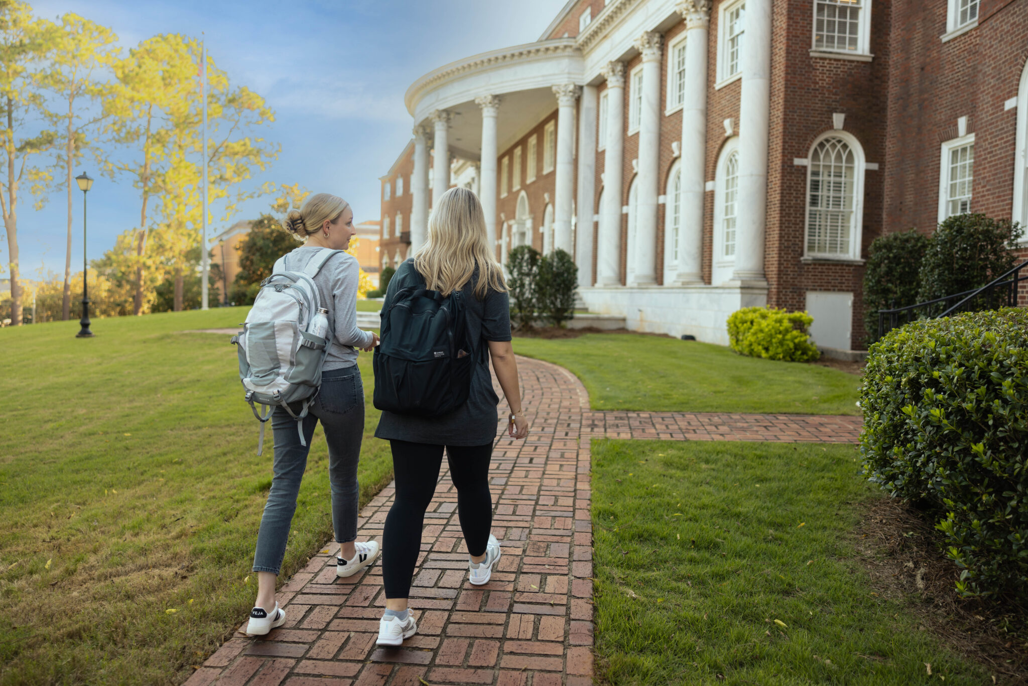 Two students walking on the front lawn of Mercer Law
