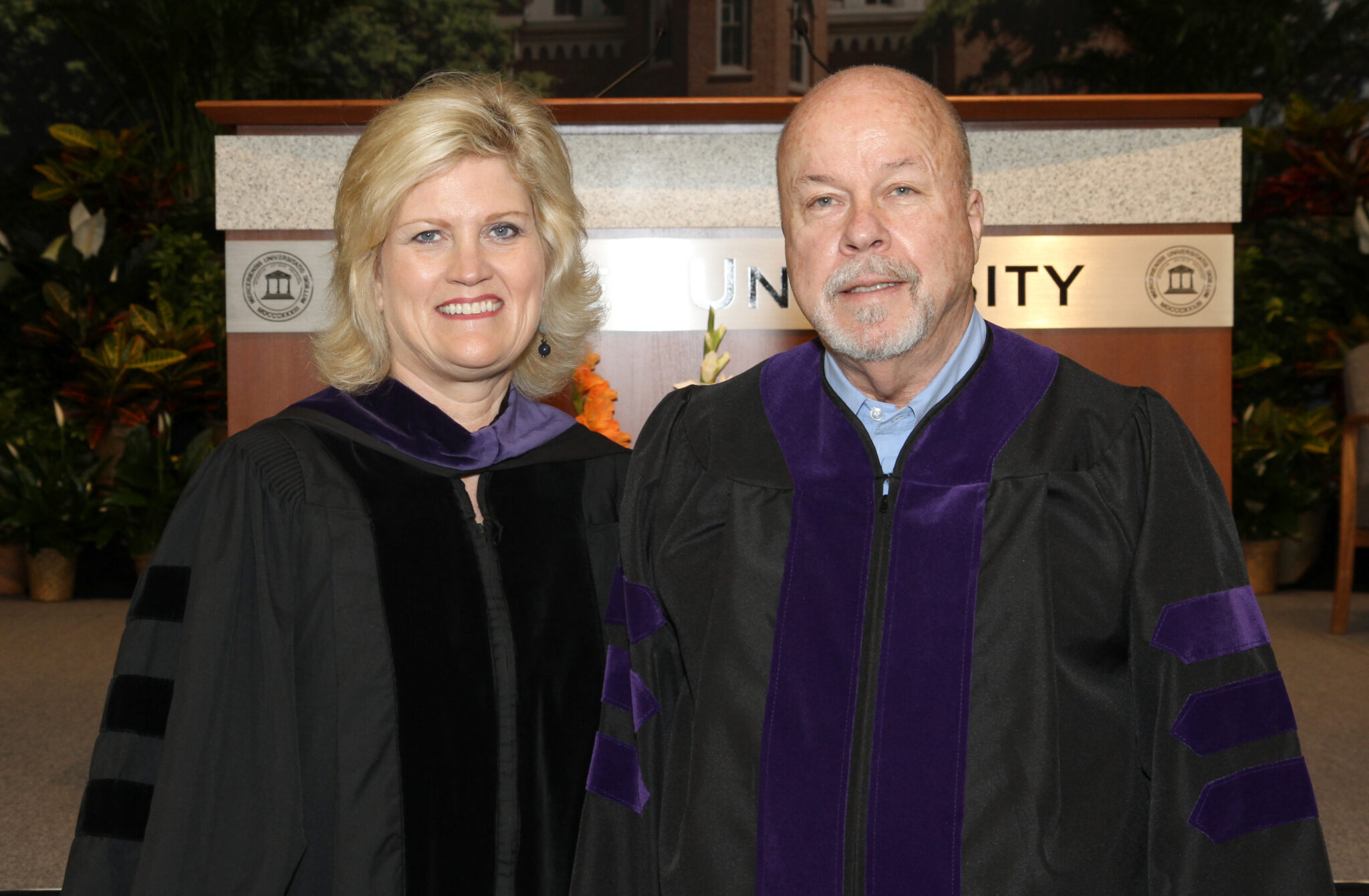 Marilyn Sutton and George Phillips pose together in law school graduation regalia