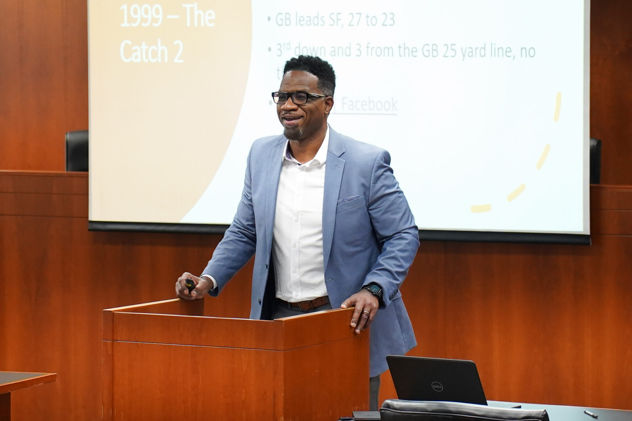 Vernon Strickland standing at a podium in front of a projector screen