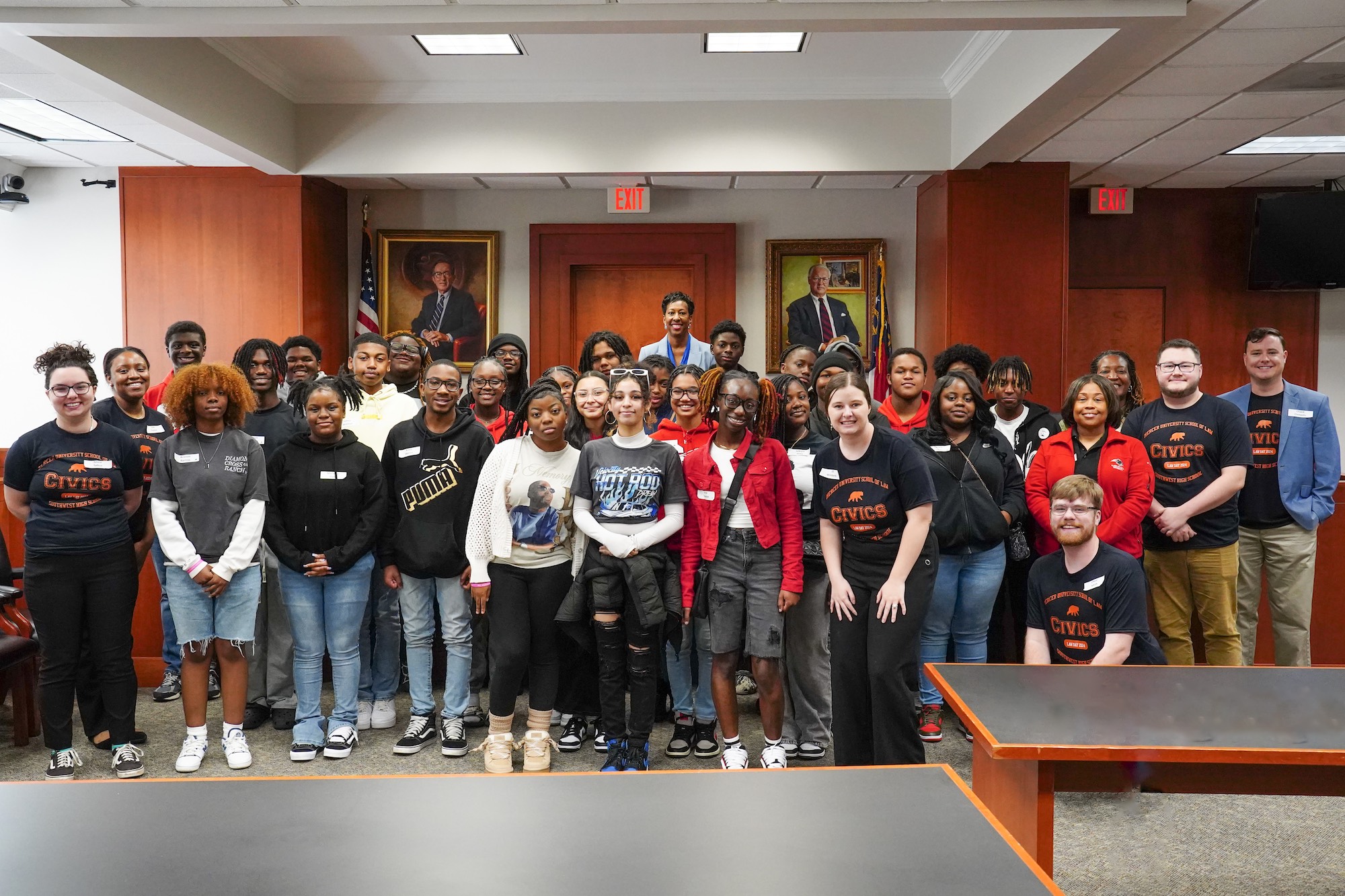 Large group of Southwest High School civics field placement students and Mercer Law civics field placement students standing in front of the bench in the Mercer Law courtroom.