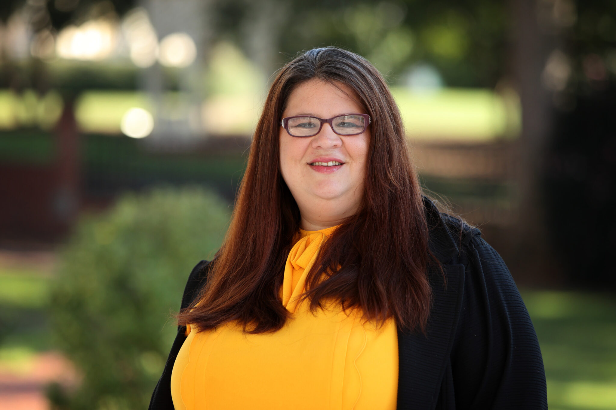 Photo of Michelle Hook Dewey with trees in the background