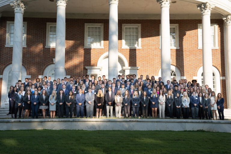 Students standing on the front porch of the law school in professional dress