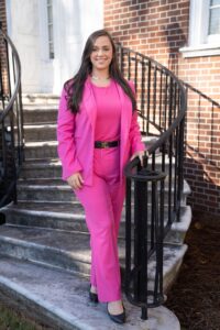 Image of Hannah Frantz in a pink suit standing on a stairwell