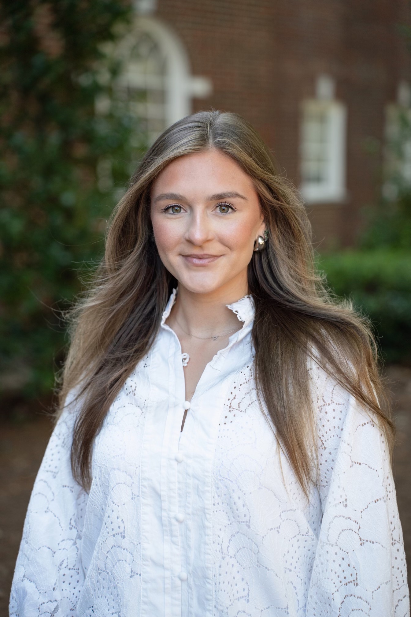 Michaela Manley in a white shirt in front of a brick building