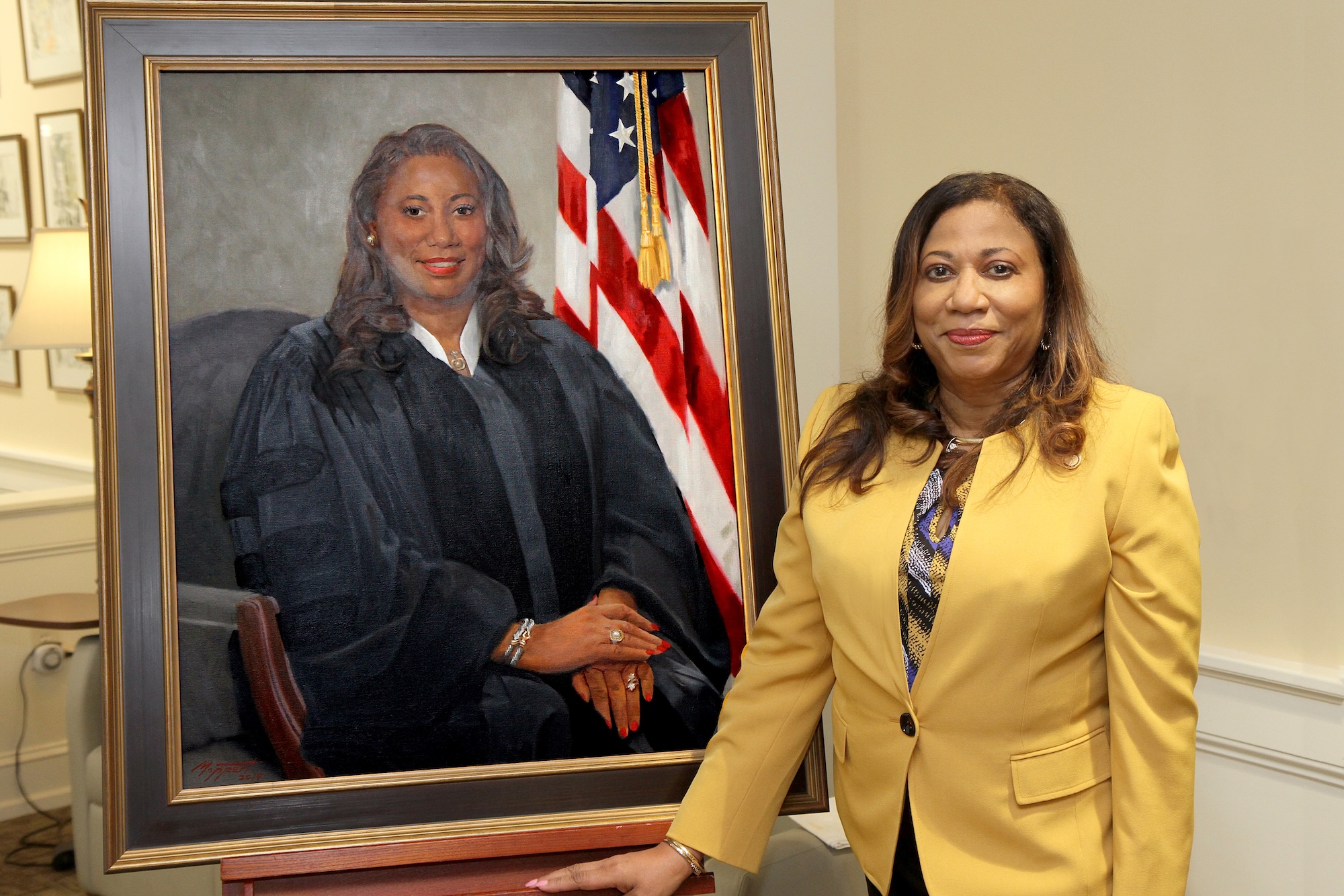 Judge Yvette Miller stands beside her portrait