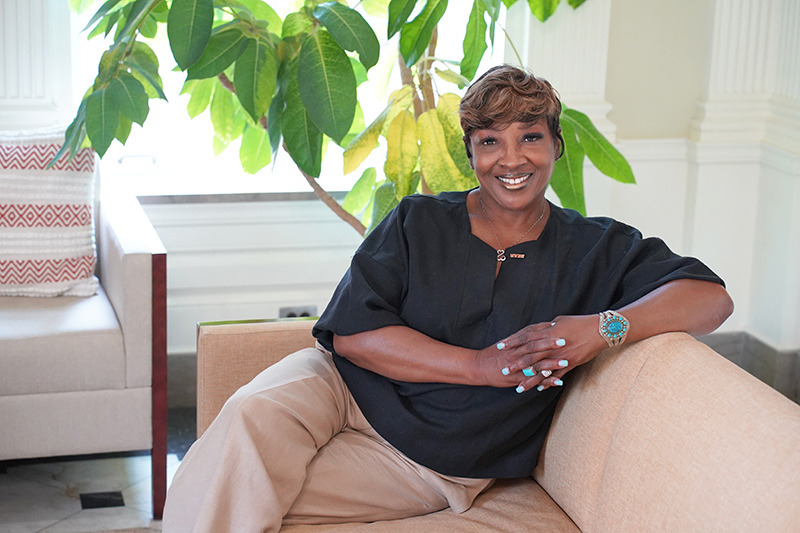 Bernadine Jackson sitting on a bench in front of a window