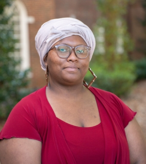Jaelynn Gillis stands in front of a brick wall in a red shirt