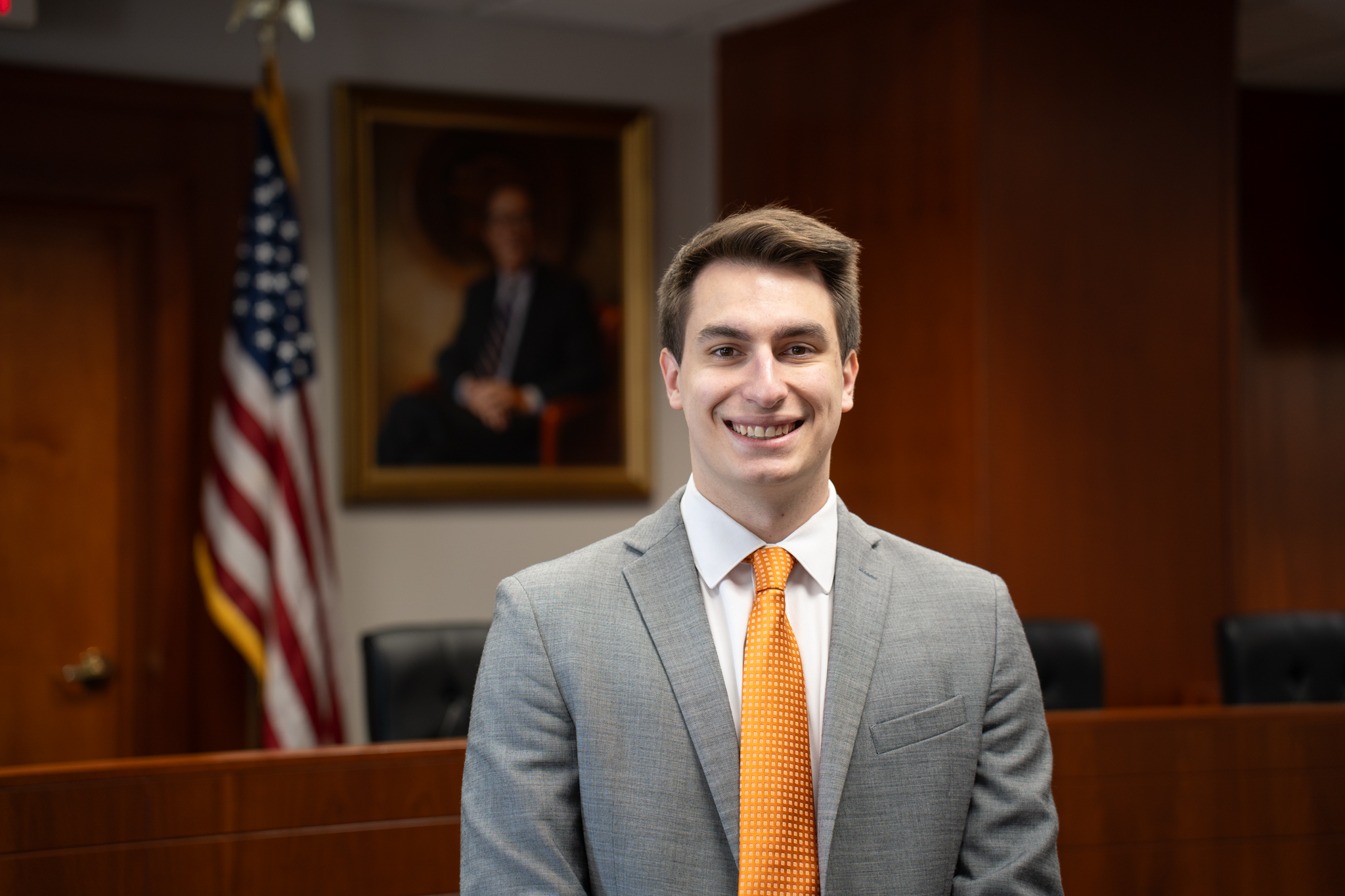 Peter Alexander standing in front of an American flag