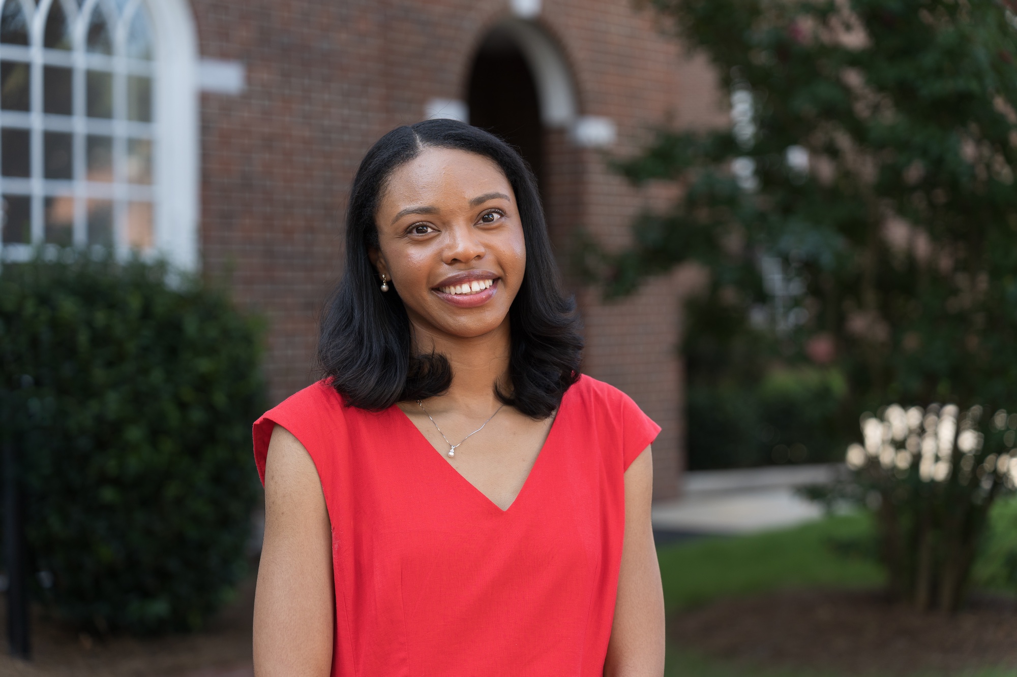 Jayanna Cameron stands in front of a brick wall