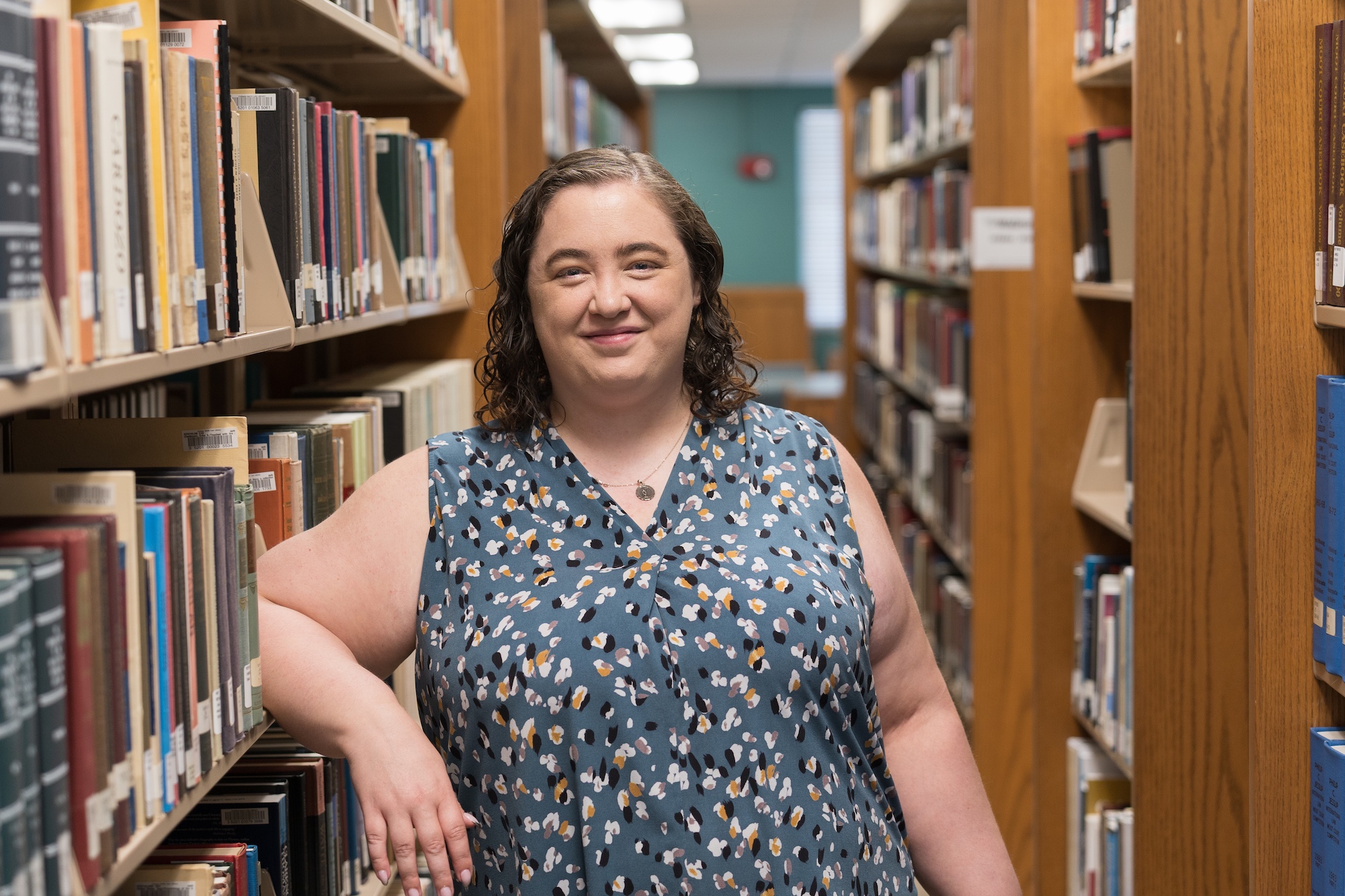 Savanna Nolan stands in front of a library shelf